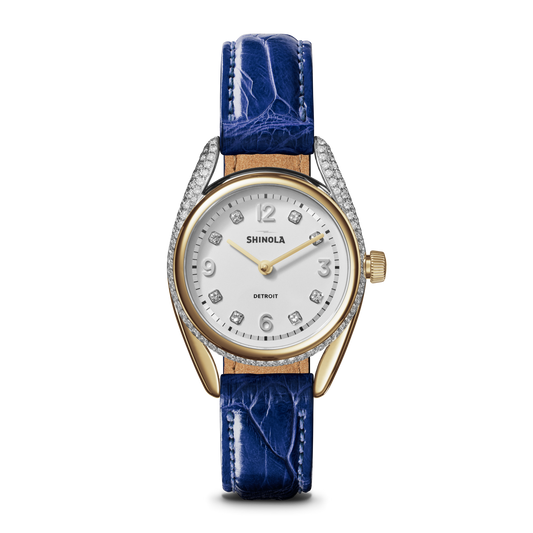 The Shinola Diamond Derby Watch features a sapphire alligator strap, diamond index dial, gold-tone hands, crystal-accented bezel, and the Shinola logo below 12 o’clock.