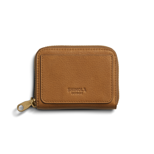 The Shinola Pocket Small Zip Around Wallet - Tan features natural leather, a gold zipper pull, and "Shinola Detroit" embossed on the front, shown on a plain white background.