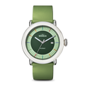 The Shinola Detrola Watch - Deep Olive features a round face, light green dial, white bezel, and green leather strap. This modern wristwatch displays the date and has colorful markers encircling the edge.