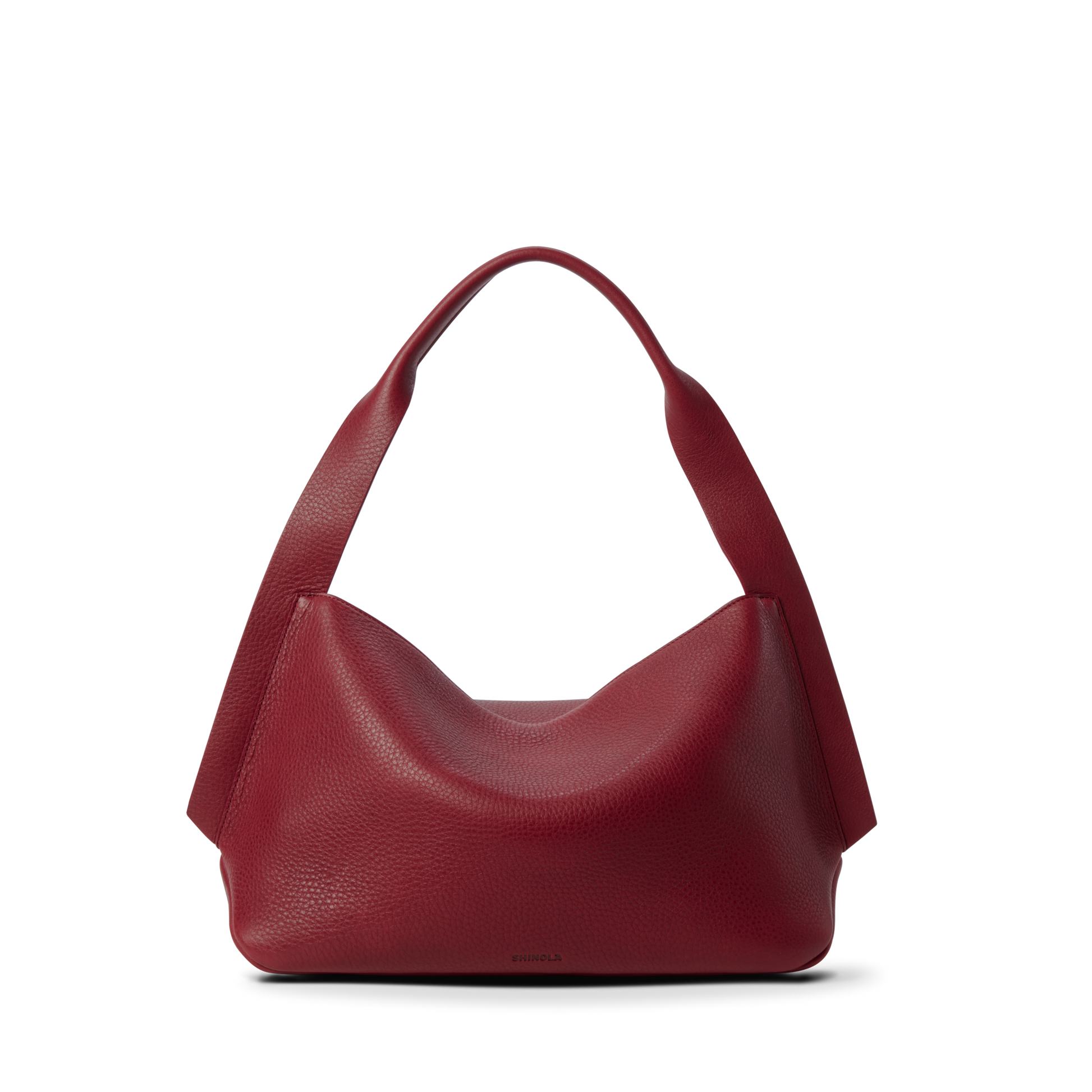 The Shinola Medium Derby Shoulder Bag - Ruby is a textured, natural grain leather handbag in deep red with wide handles. It has a slouchy, soft structure and no visible hardware or embellishments, shown upright on a white background.