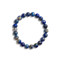 The 8mm Beaded Lapis Bracelet by Shinola features round blue and gray marbled lapis stones with a small engraved metallic bead, arranged in a circle—an elegant gemstone accessory.
