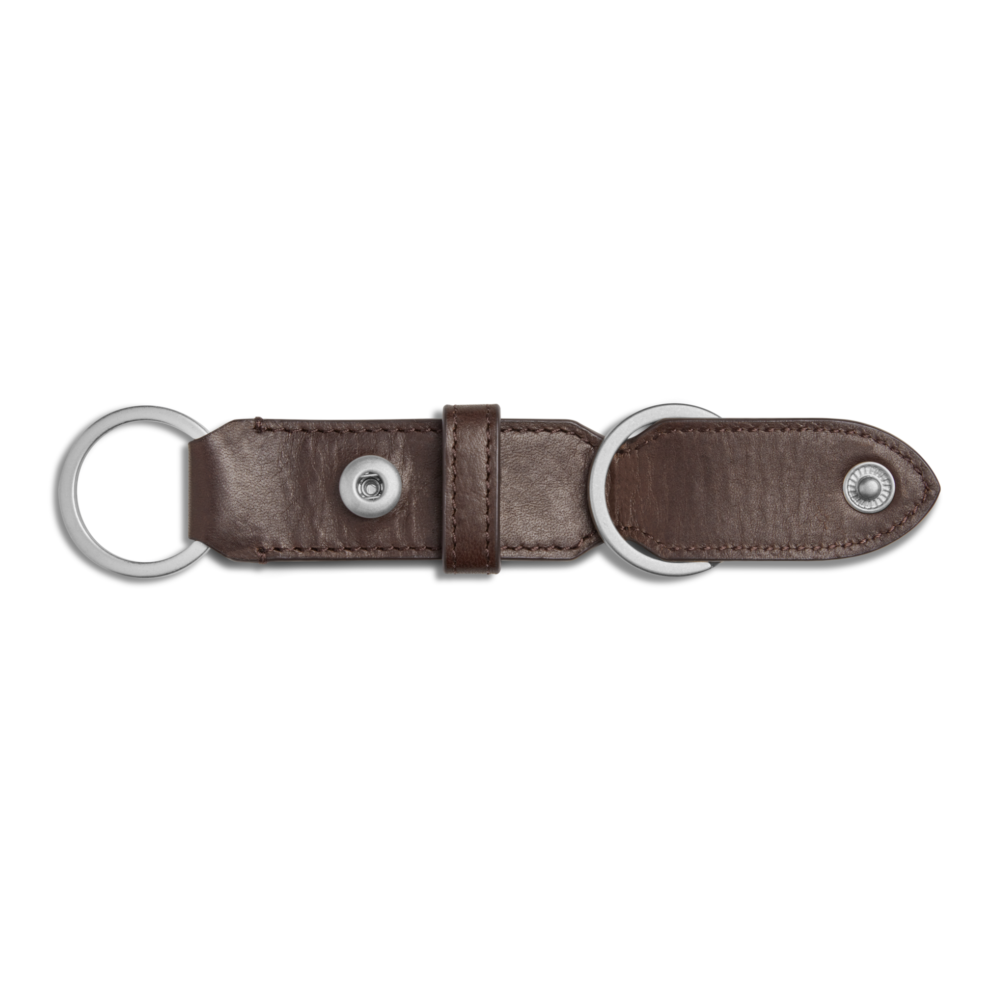 The Shinola Leather Valet Key Fob in dark brown features two silver rings at each end and a button snap closure, shown on a plain white background.