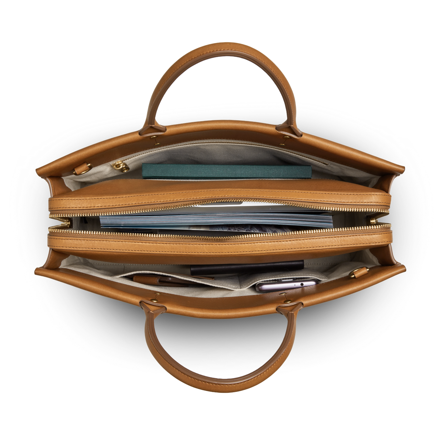 Top-down view of the Shinola Day Satchel - Tan, a versatile leather bag with beige interior, laptop compartment, and multiple sections for your book, smartphone, and essentials—ideal for life on the go.