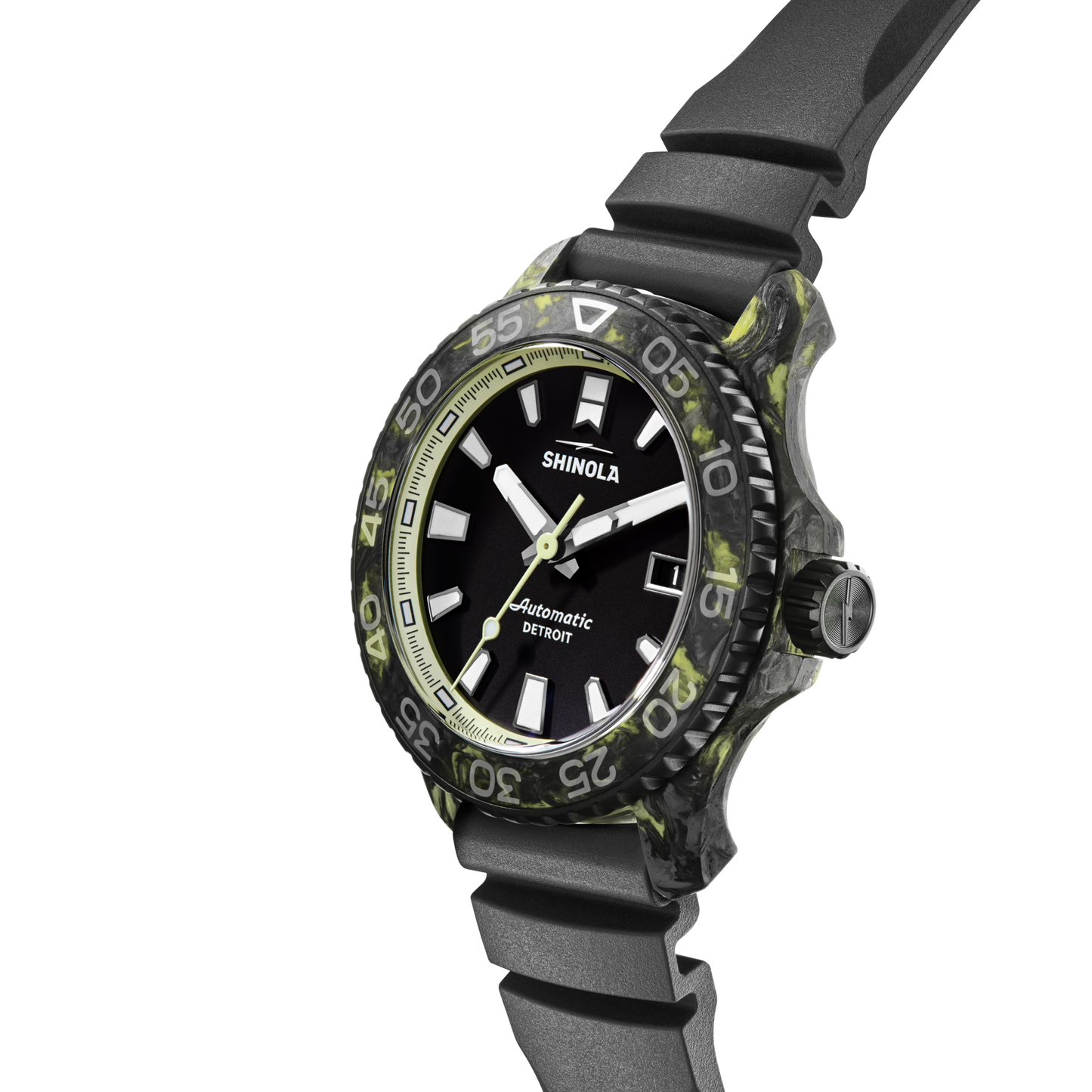 The Shinola Forged Carbon Monster Watch features a Swiss-made automatic movement, black and green marbled bezel, black dial with white hour markers, and a black rubber strap, displayed at an angle on a white background.