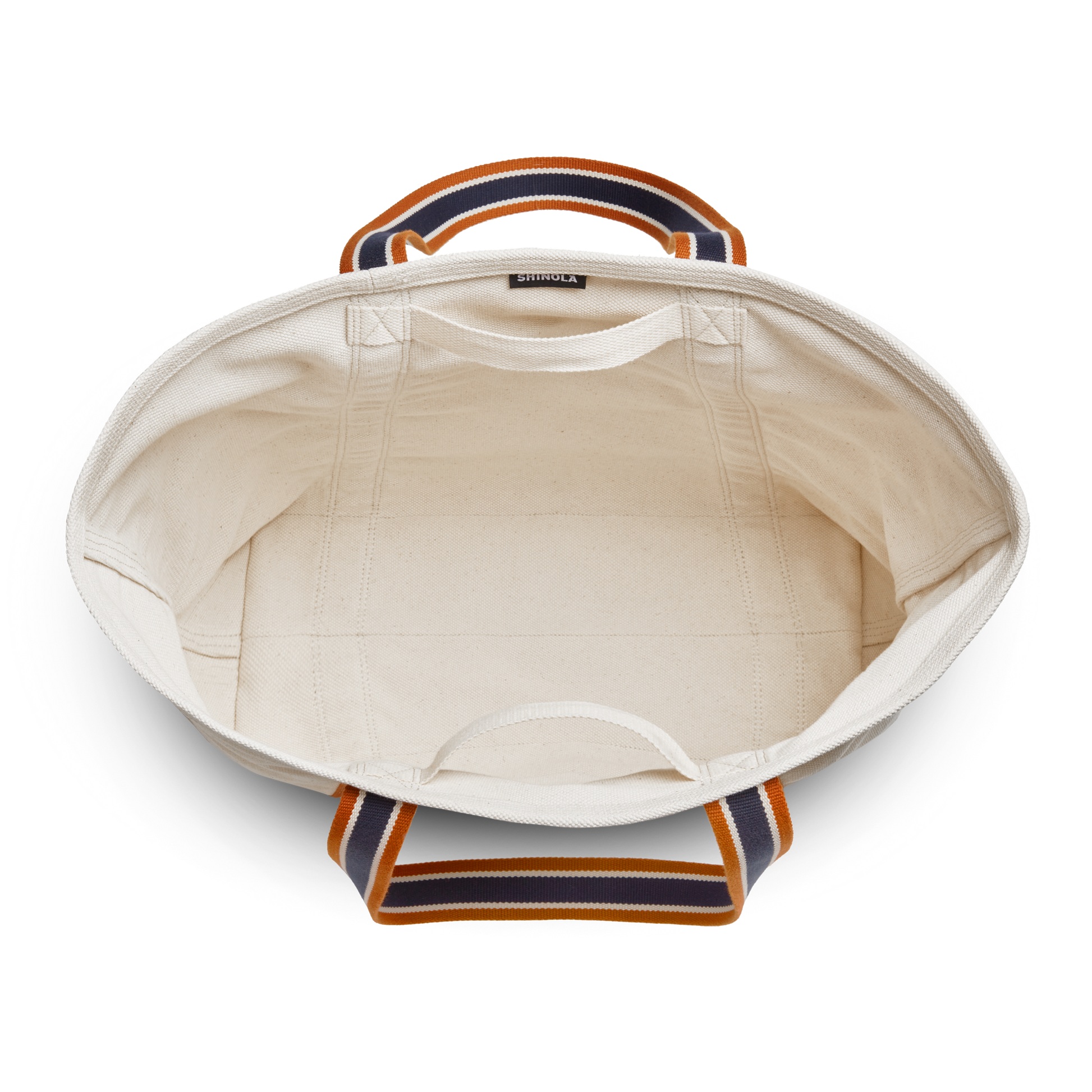 Top view of the Large Easy Canvas Tote - Natural by Shinola, featuring sturdy orange and navy striped handles. This spacious, unlined tote provides ample room for essentials.