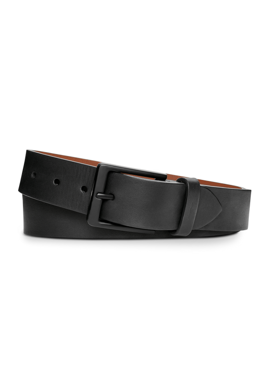 The Shinola 1 1/2" Lightning Bolt Keeper Belt in black nappa leather, featuring a matte black rectangular buckle with a subtle lightning bolt symbol, is shown coiled on a white background.