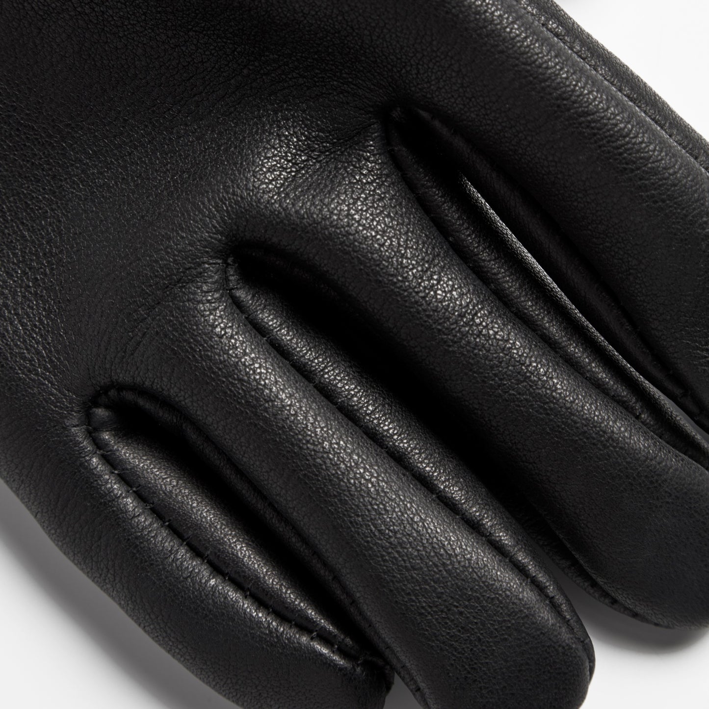 Close-up of Shinola Lined Leather Gloves - Black, highlighting the texture and stitching on the fingers against a white background. Expertly crafted in the USA from premium bovine leather.
