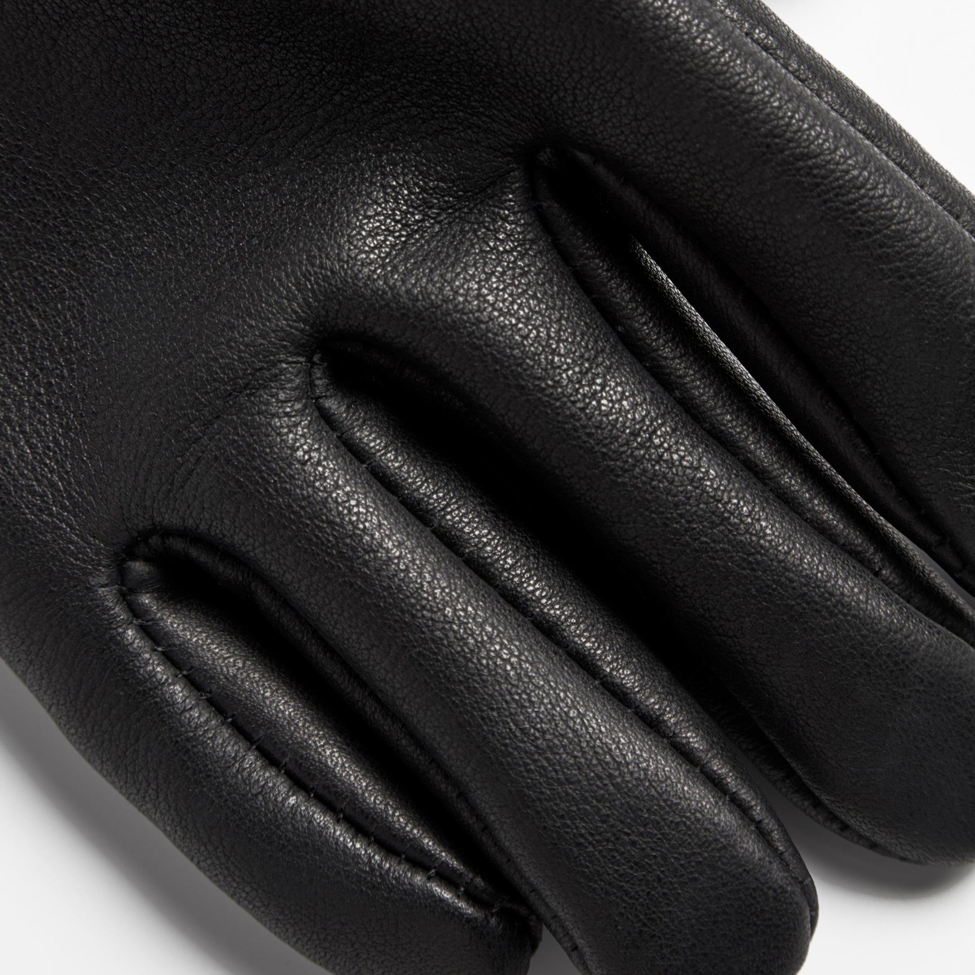 Close-up of Shinola Lined Leather Gloves - Black, highlighting the texture and stitching on the fingers against a white background. Expertly crafted in the USA from premium bovine leather.