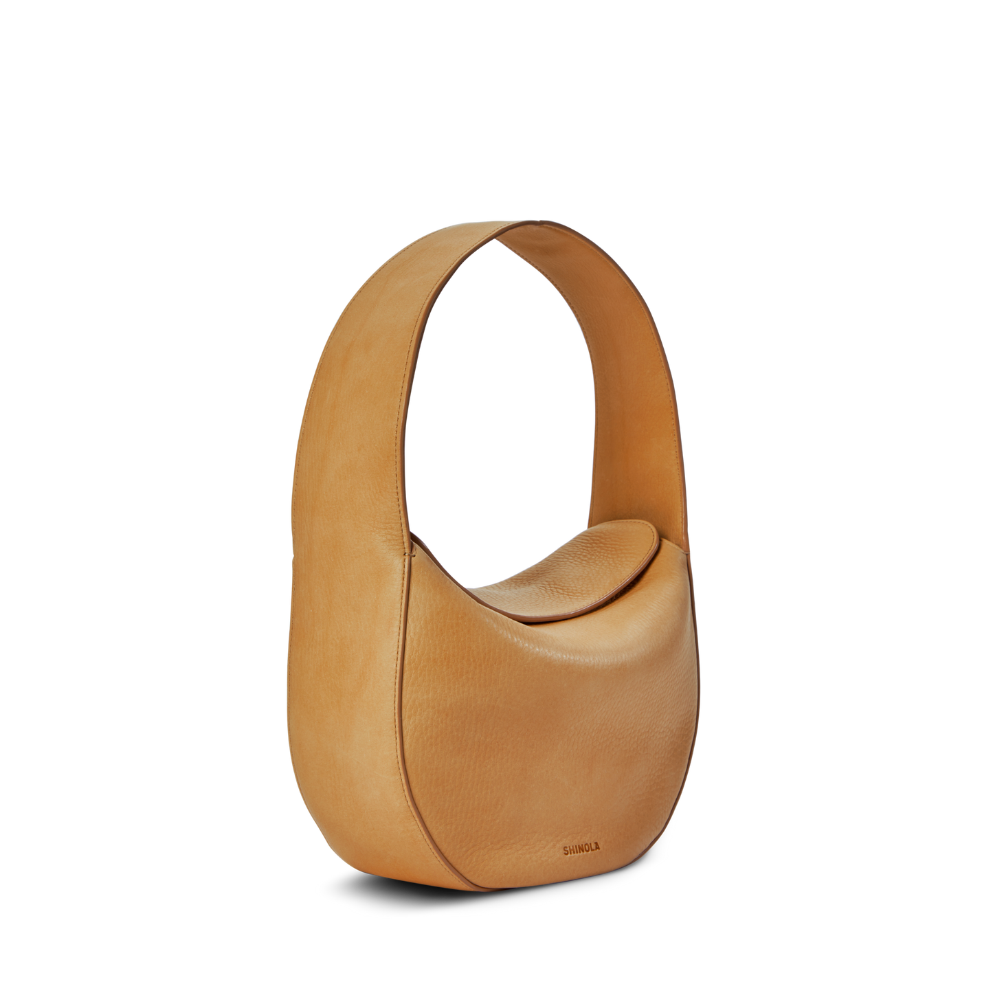 The Shinola Small Shoulder Bag - Honey is a premium tan leather bag with a curved, wide strap and structured, rounded body. Its smooth texture and minimalist design make it perfect as a small shoulder bag, shown against a plain white background.