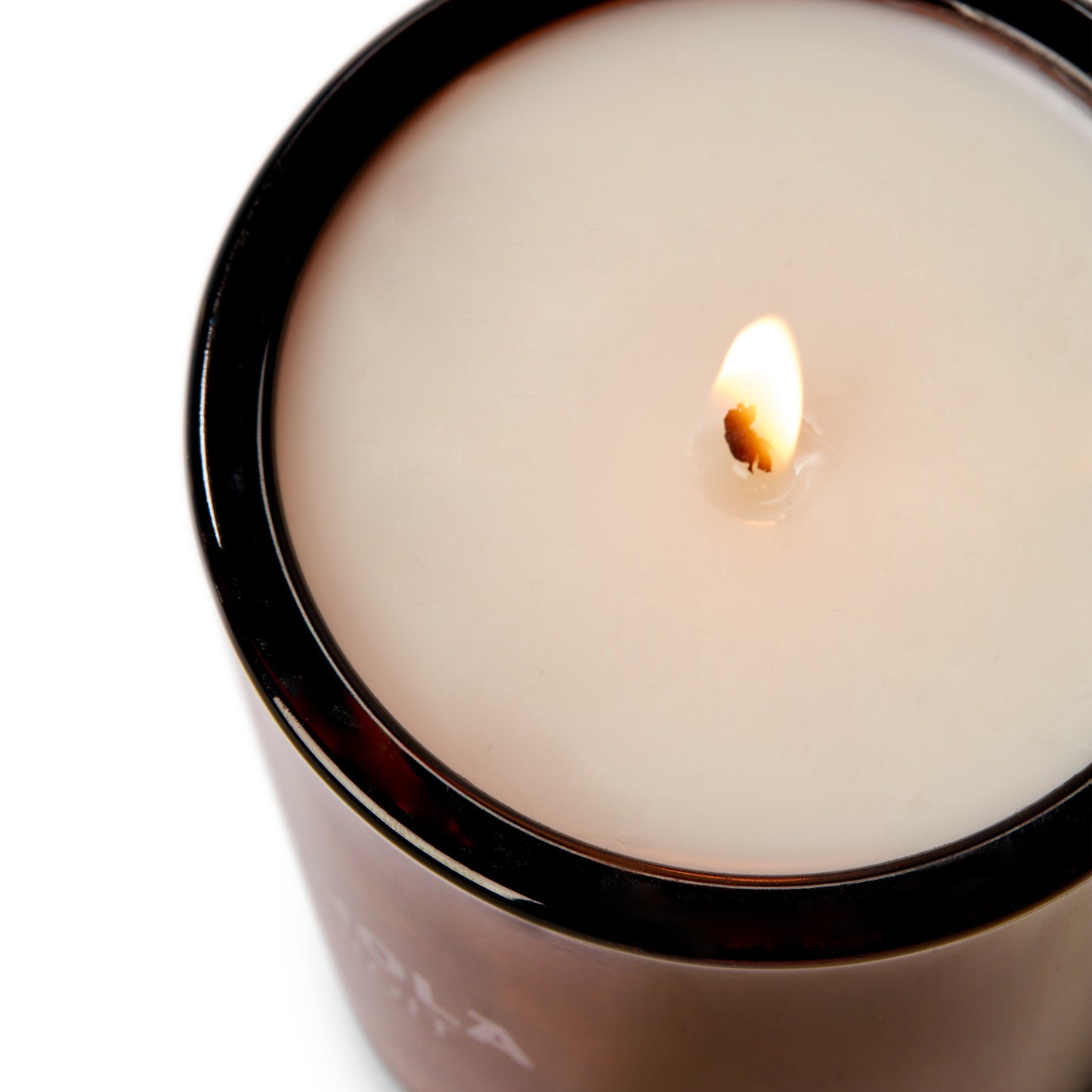 A close-up of the Shinola Rose 8 oz Scented Candle shows its lit coconut soy wax in a dark brown glass container, highlighting the soothing floral aroma.