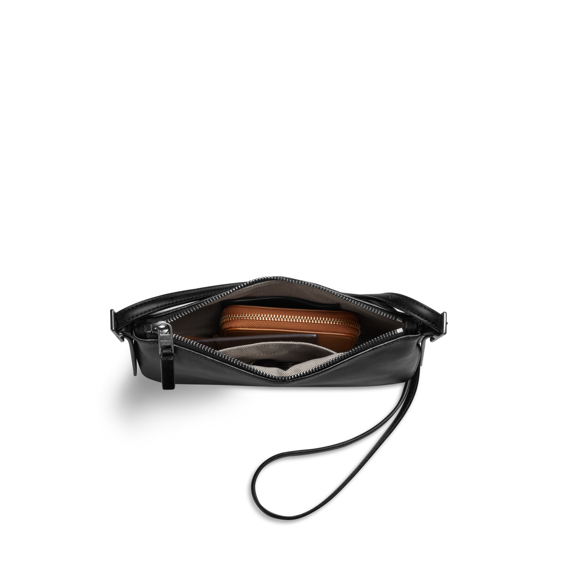 The Shinola Small Bixby Crossbody in black natural leather, shown partially unzipped to reveal a brown wallet and small gray item inside, makes the perfect everyday accessory against a plain white background.