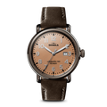 The Shinola Runwell Watch features a rose gold case, deep brown leather strap, round tan dial with silver hour markers and hands, date window at 3 o'clock, and displays "Shinola" and "Argonite-705 Detroit" on the face.