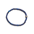 The Shinola 4mm Beaded Lapis Bracelet features round, dark blue lapis stones and a single engraved metallic bead, arranged in a circle against a white background.