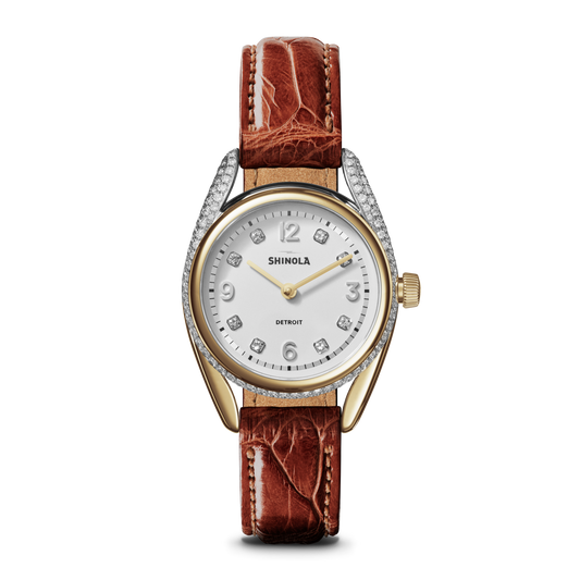 The Shinola Diamond Derby Watch features a two-tone case, auburn alligator strap, diamond hour markers, and a white dial with silver numbers and hands.