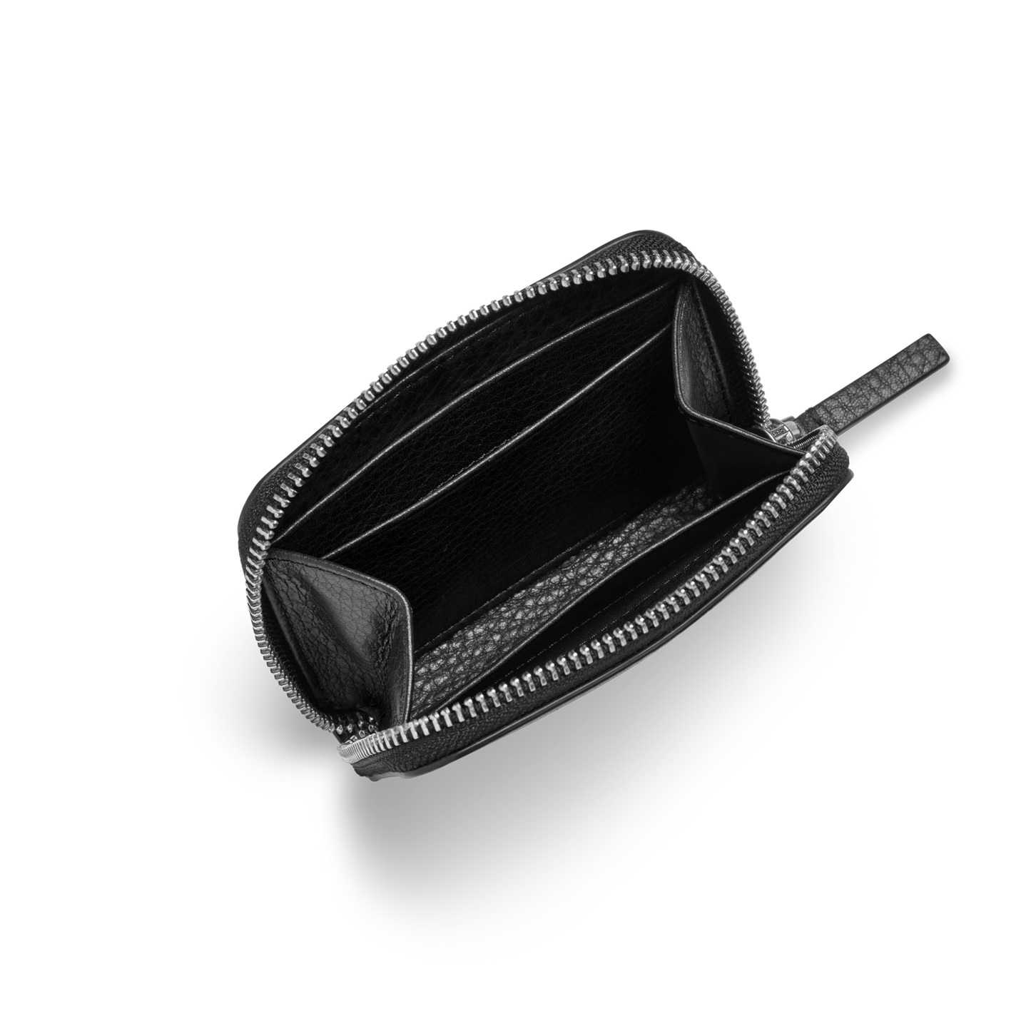 The Shinola Small Zip Wallet - Black, made from natural grain leather, is open on a light gray background showing its two main compartments and an interior divider. This compact wallet is empty and elegantly displayed.