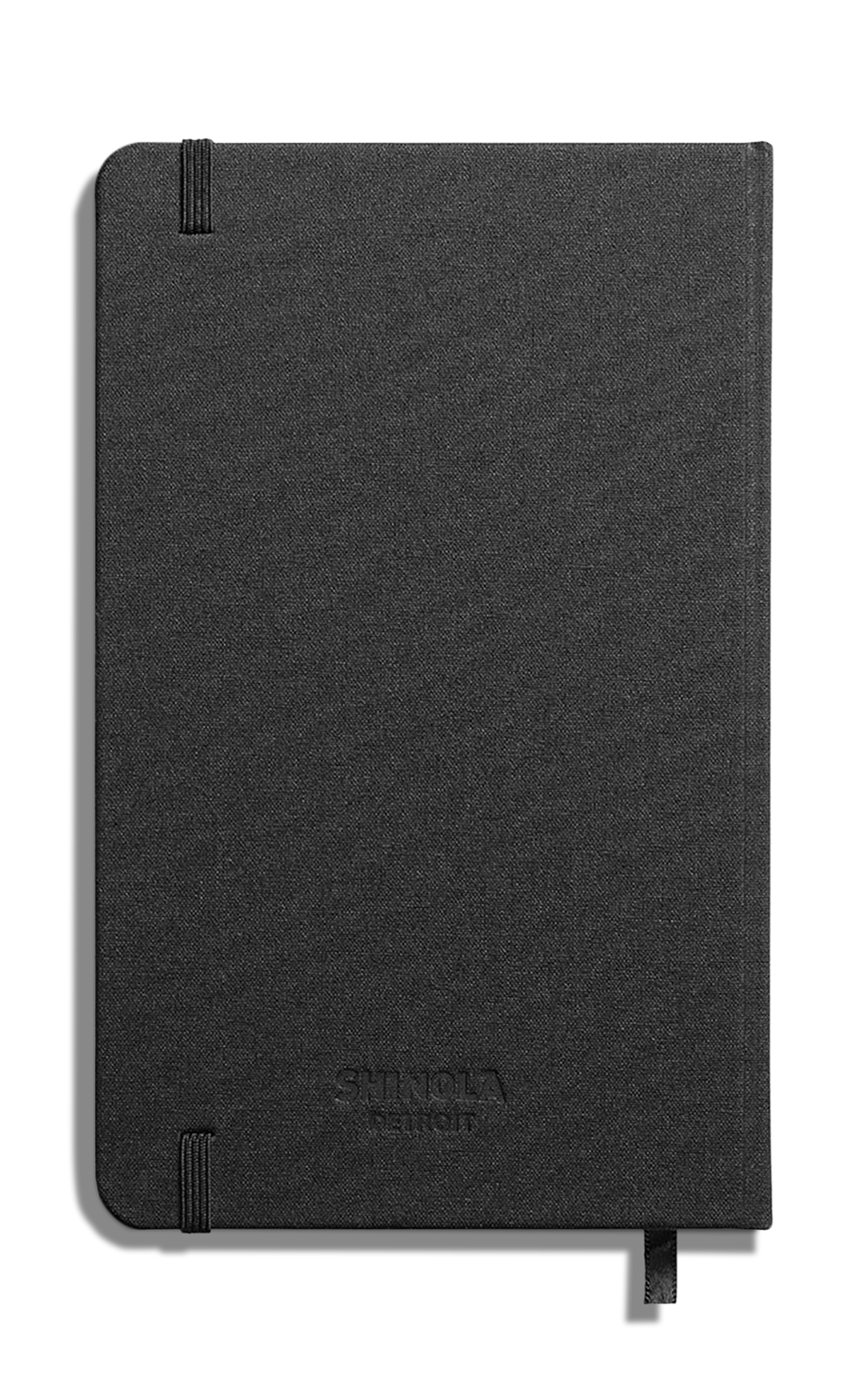 The Shinola Medium Hard Plain Journal - Black features a textured hard linen cover, elastic closure, and ribbon bookmark. "Shinola" is subtly embossed on the front. Photographed against a white background. Made in America.