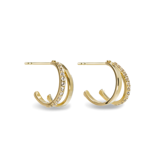 The Shinola Diamond Rivet Huggies are 14k yellow gold hoop earrings with two parallel bands—one plain, one set with brilliant cut diamonds—shown against a white background.