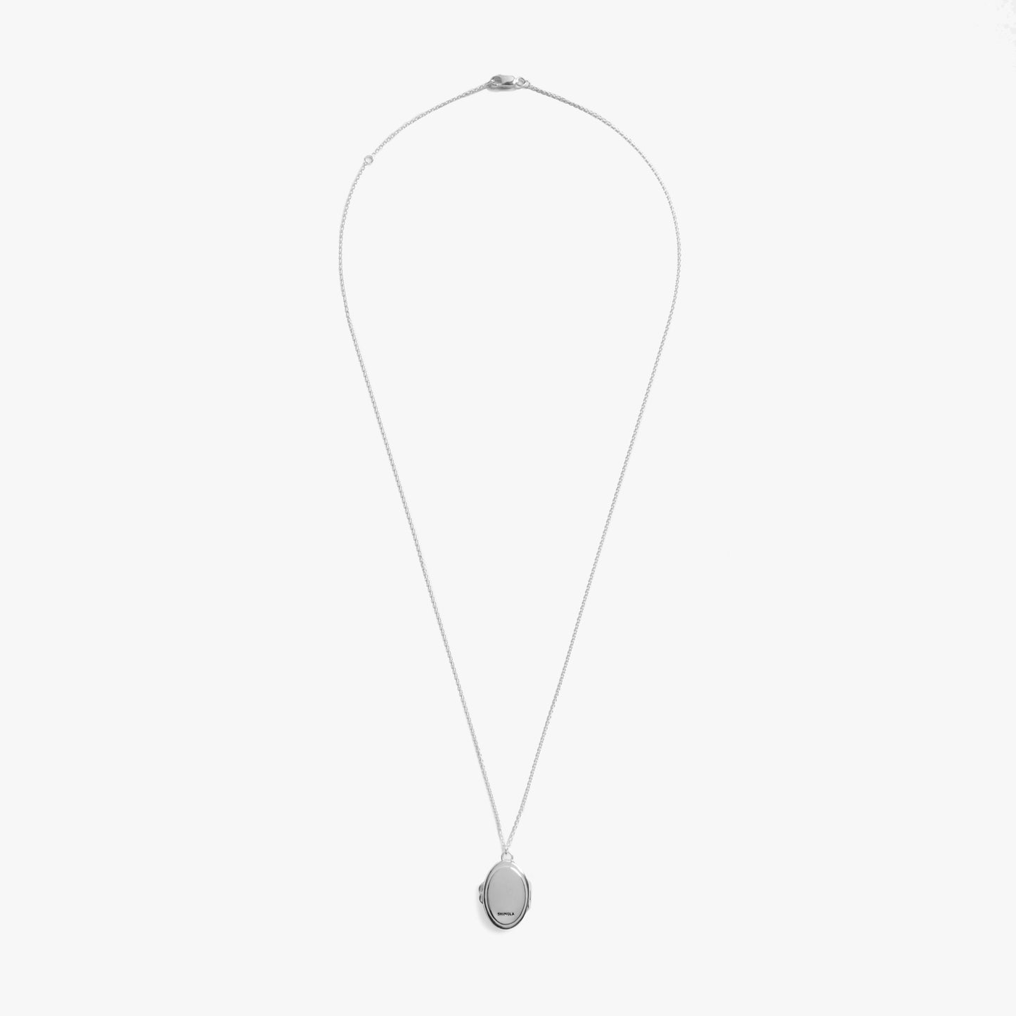 The Shinola Heirloom Statement Locket Necklace features a sterling silver oval locket on a slim chain, elegantly displayed against a plain white background.