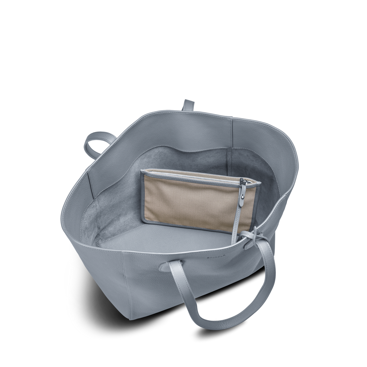 The Shinola Runabout Tote Bag - Mist features light gray pebbled leather with two handles. Viewed from above, a beige zipper pouch is attached inside against the bag's soft, suede-like interior lining.