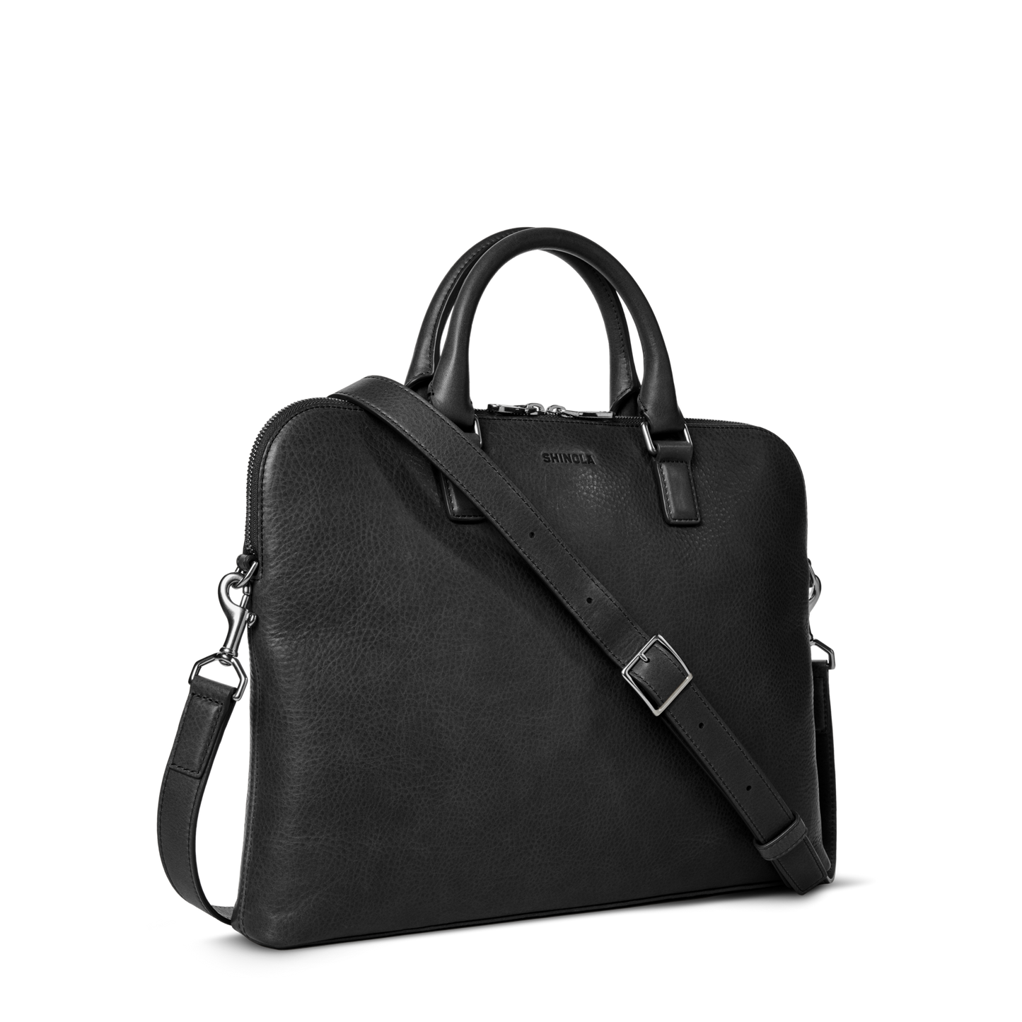The Shinola Portfolio Briefcase - Black is crafted from European grain leather, featuring dual top handles, a detachable adjustable shoulder strap, zippered top, subtle front branding, and a slim minimalist design.