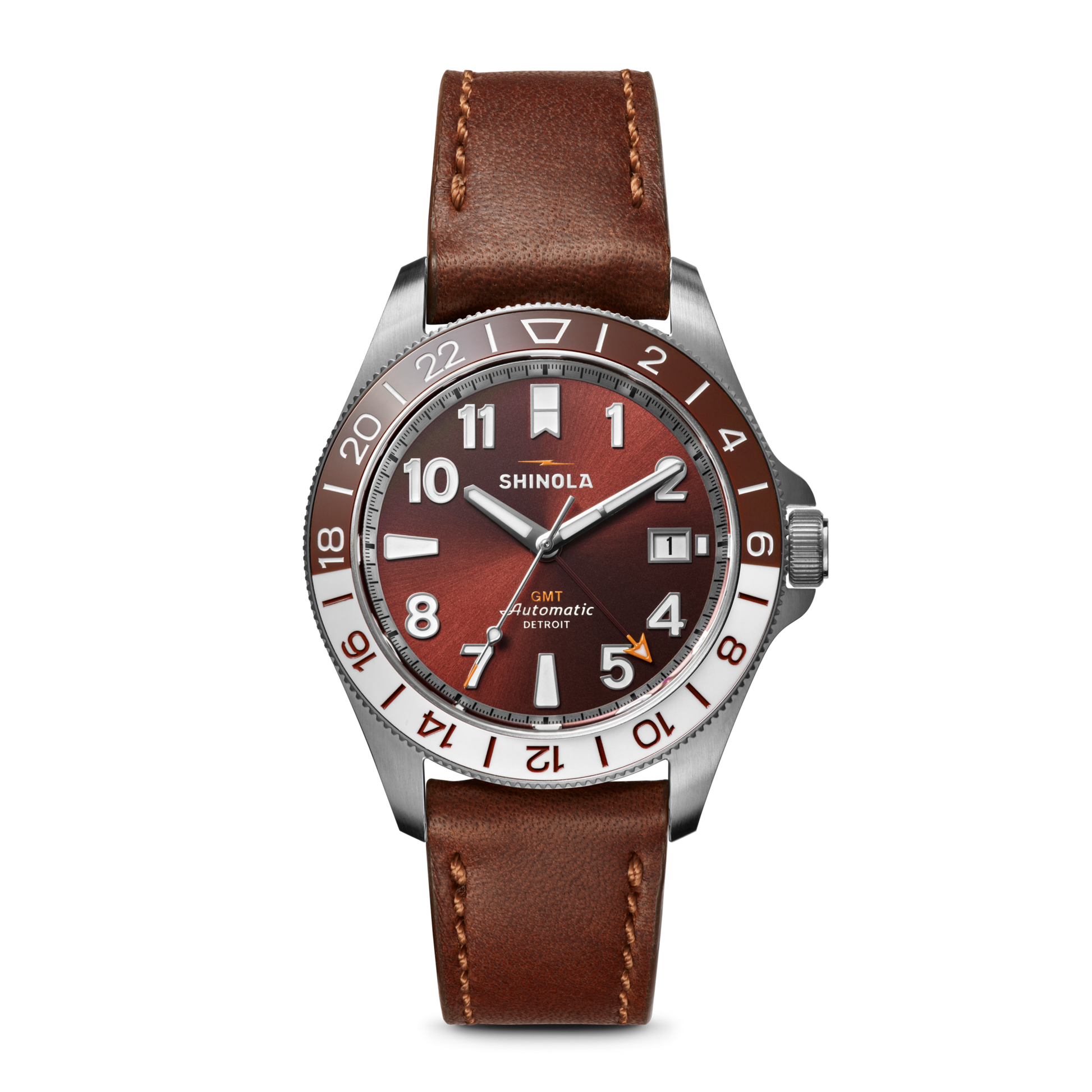 The Shinola Monster GMT Automatic Watch - Whiskey features a brown leather strap, silver case, red-brown gradient dial, white/silver markers, and date window—a sophisticated travel watch for the modern explorer.