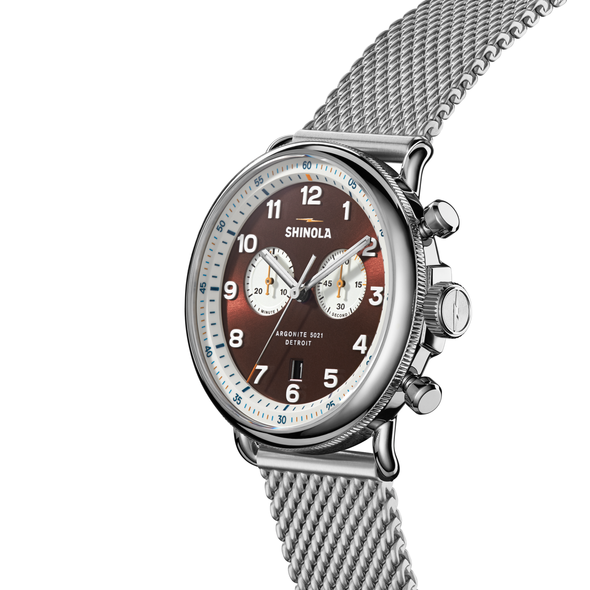 The Shinola Canfield C56 Chronograph Watch - Whiskey features a brown gradient dial, stainless steel mesh bracelet, two subdials, silver hour markings, blue minute markers, three side buttons, and "Shinola Argonite 5021 Detroit" on the face.