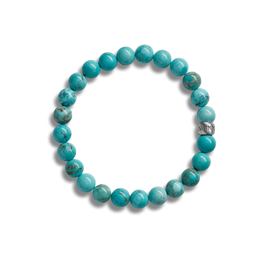 The Shinola 8mm Beaded Bracelet Turquoise features polished turquoise beads and a sterling silver accent engraved with “SHIN,” shown on a plain white background.
