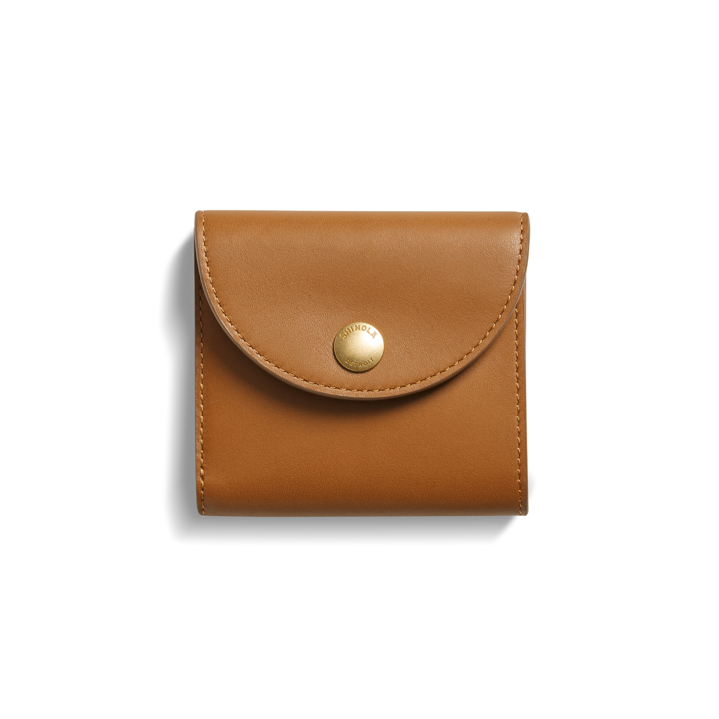 The Shinola Birdy Small Snap Wallet in tan leather, with a rounded flap and gold snap button, features card pockets and is shown on a white background with a subtle left shadow.