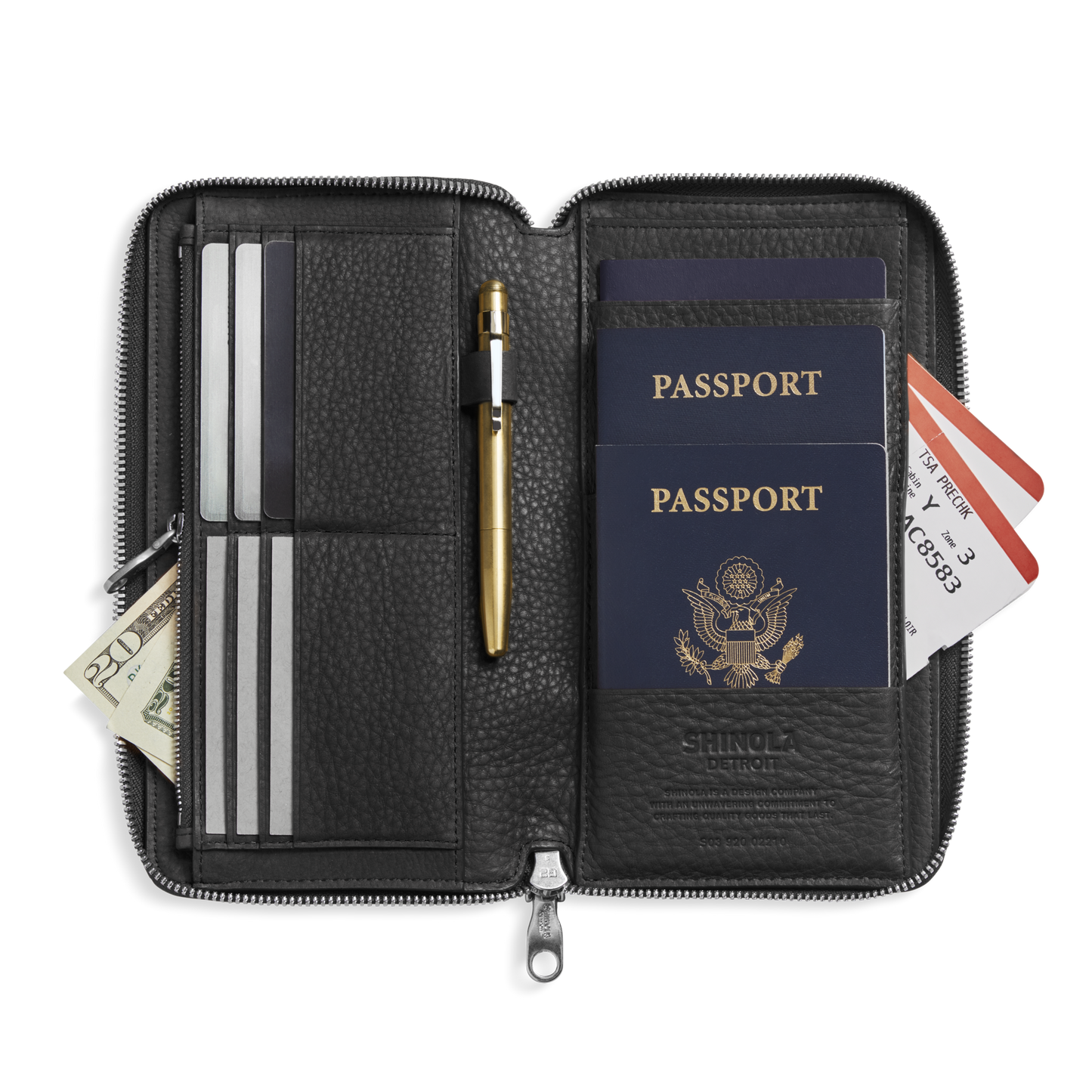 The Shinola Organizer Wallet - Black keeps two U.S. passports, a gold pen, boarding passes, cards, cash, and documents all neatly organized.
