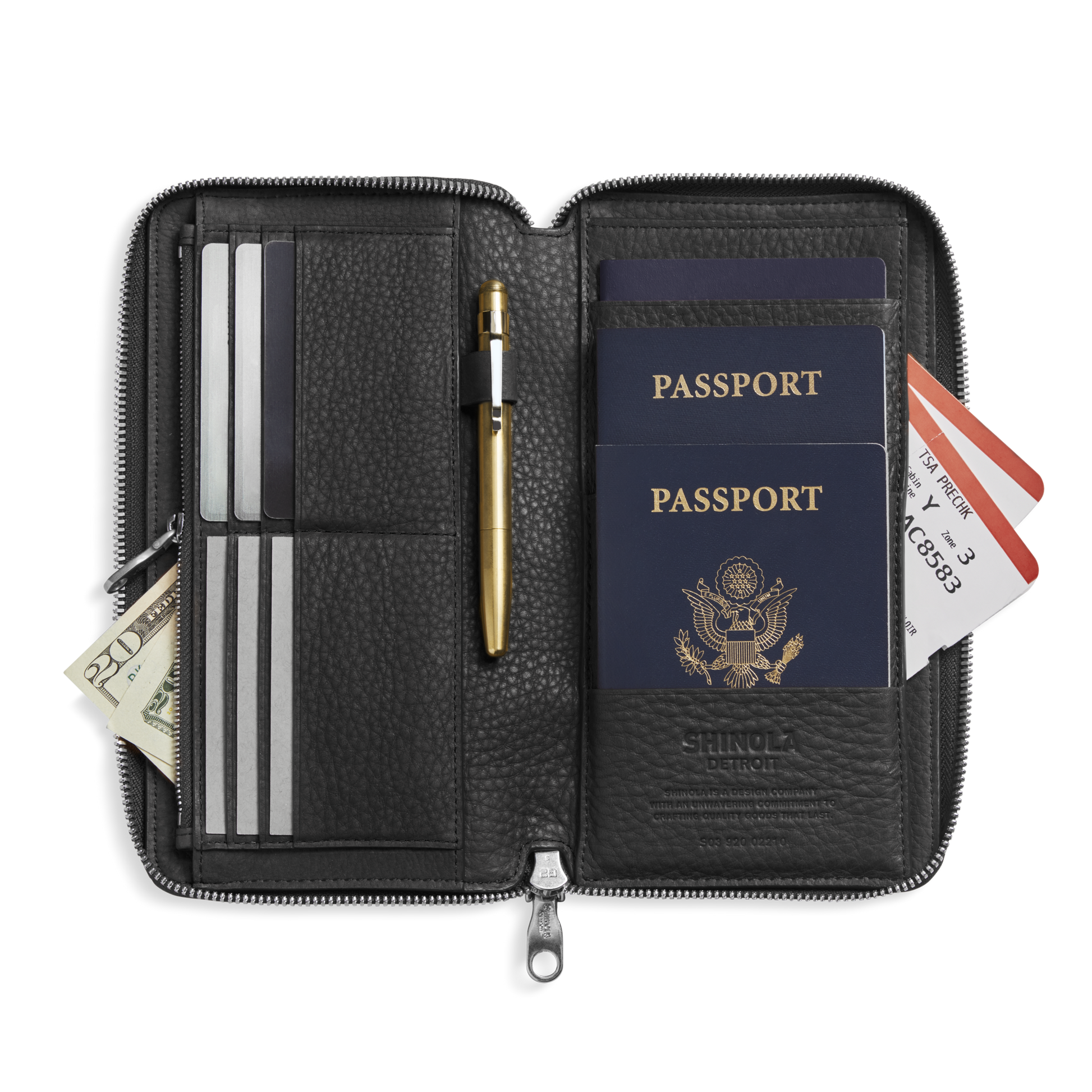 The Shinola Organizer Wallet - Black keeps two U.S. passports, a gold pen, boarding passes, cards, cash, and documents all neatly organized.