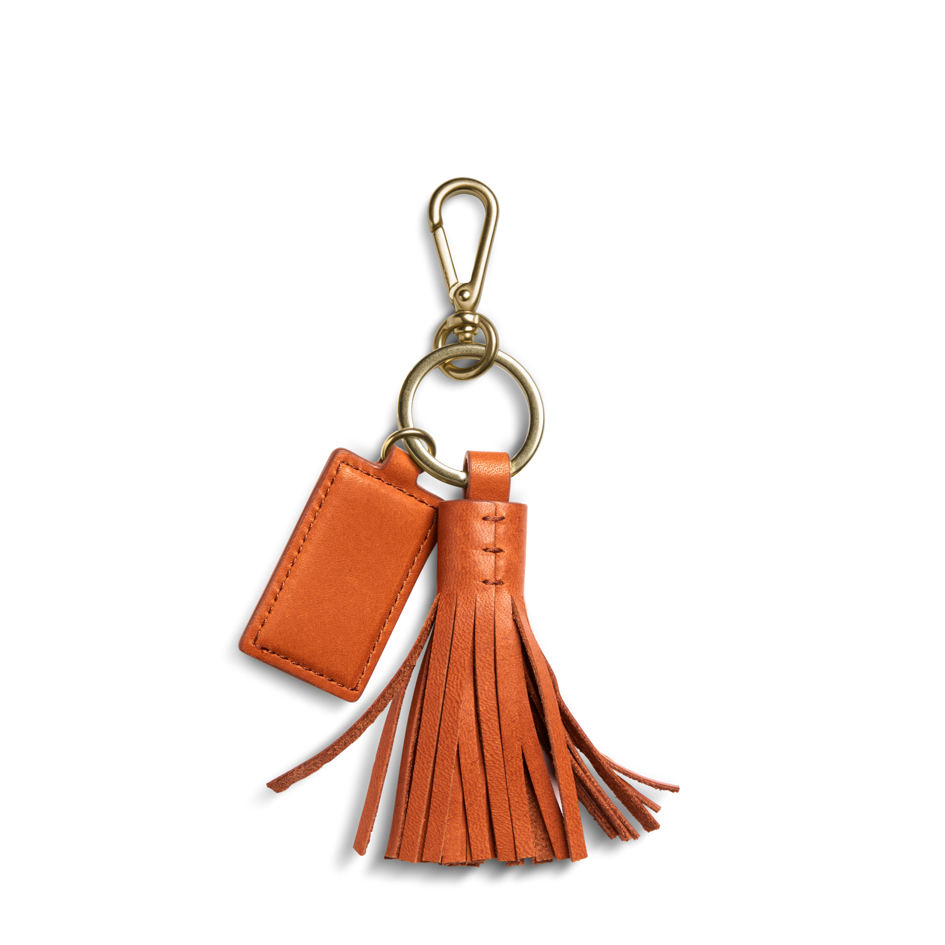 The Leather Tassel Keychain - Rust by Shinola features natural leather, a small rectangular tag, and a brass keyring with clasp, shown on a white background.