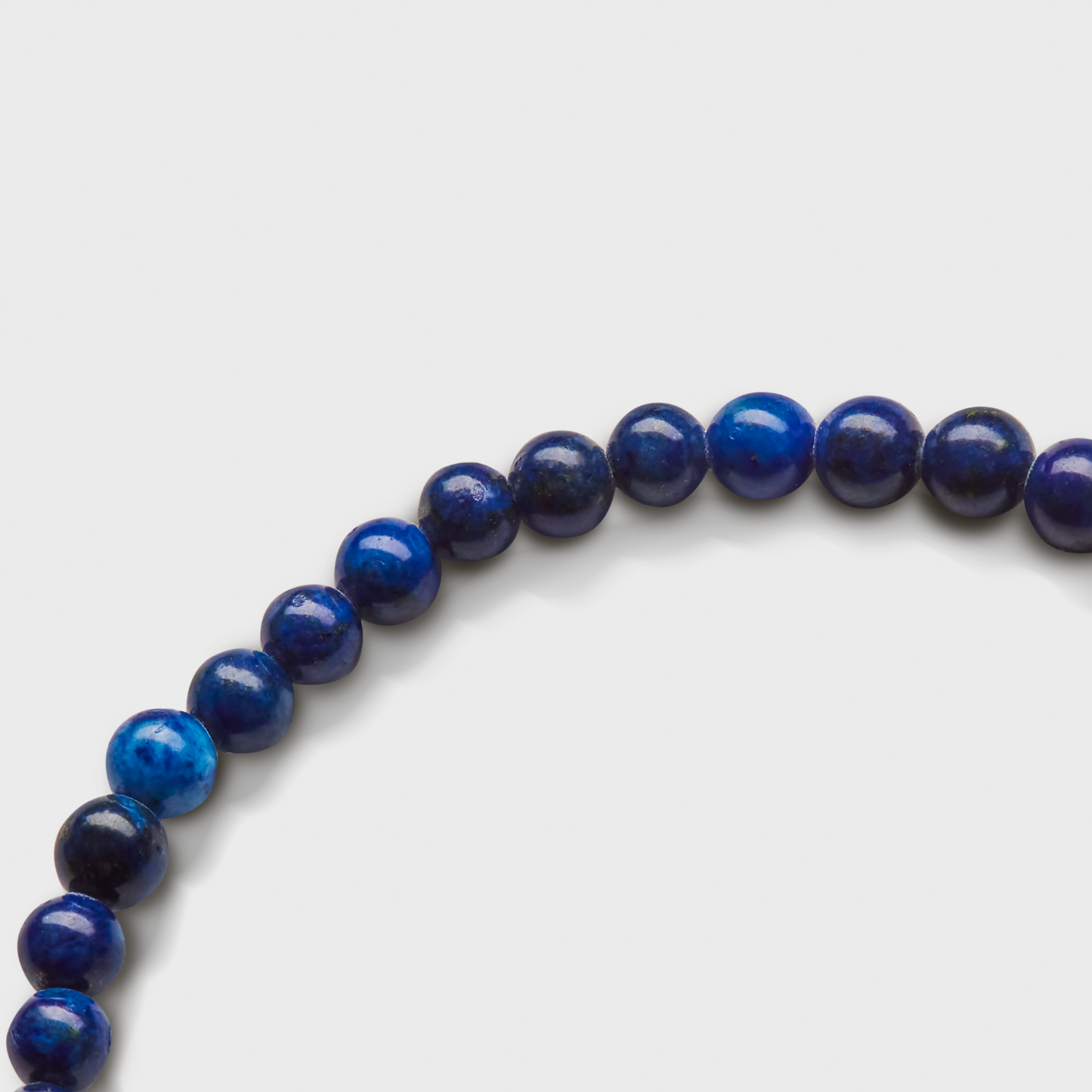 The Shinola 4mm Beaded Lapis Bracelet features a curved strand of round, polished blue lapis beads that vary slightly in shade and stand out against a plain white background.