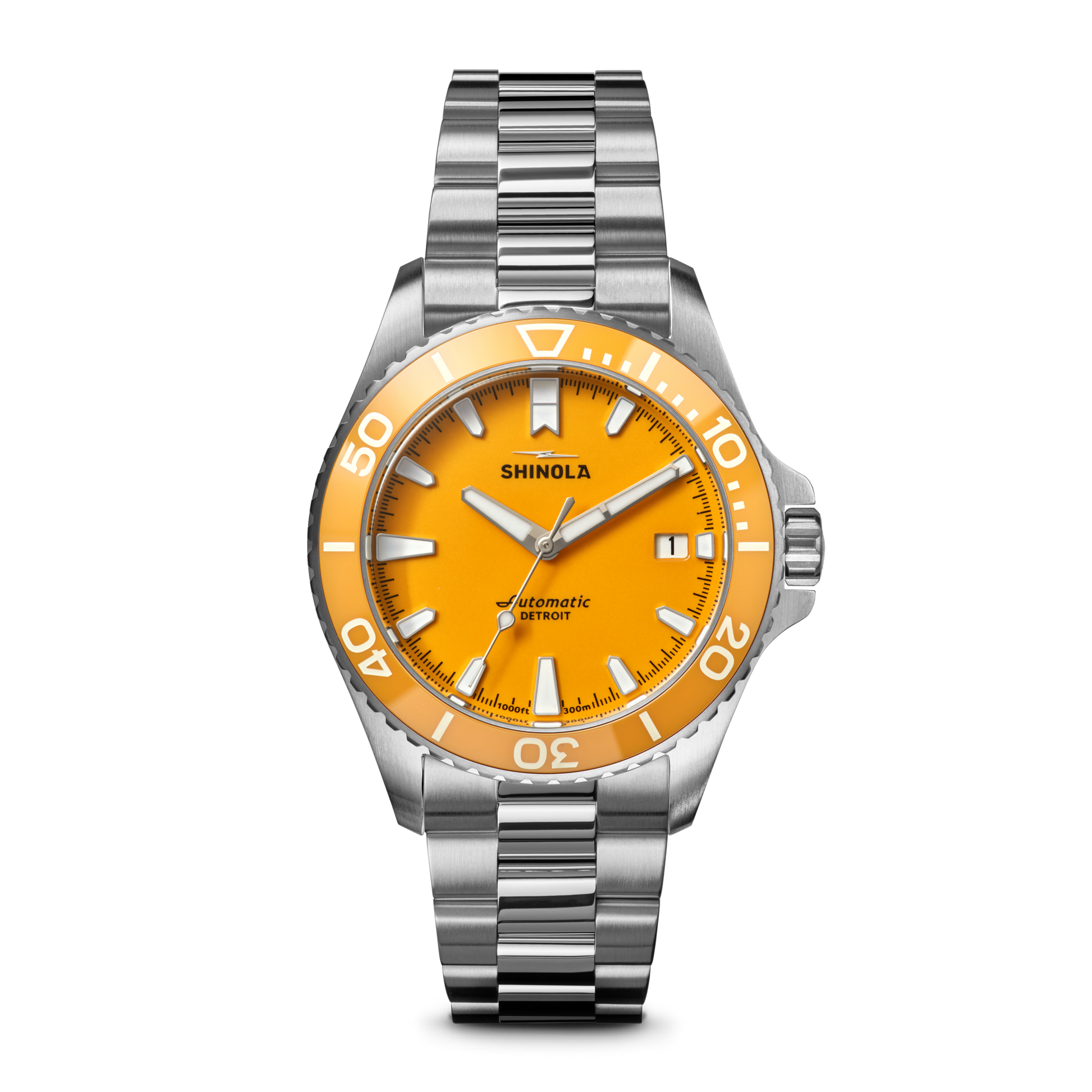 The Shinola Lake Huron Monster Automatic Dive Watch features a stainless steel case, silver metal band, bright orange face, white hour markers and hands, minute indices, and the Shinola name above the center.