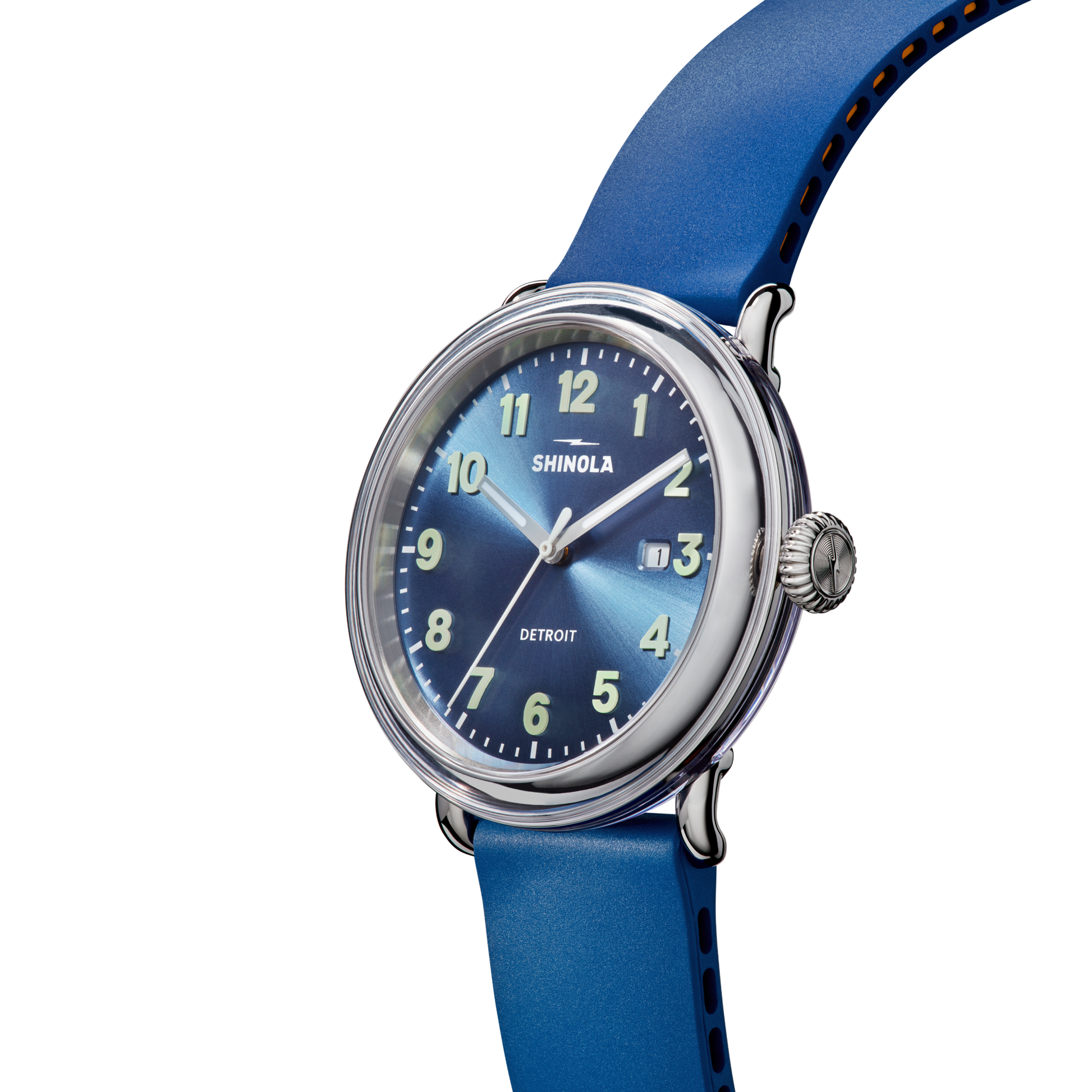 The Shinola Detrola Watch - Denim Blue showcases American design with a round face, white hour markers, silver hands, date window, and blue leather strap—all elegantly presented on a white background.