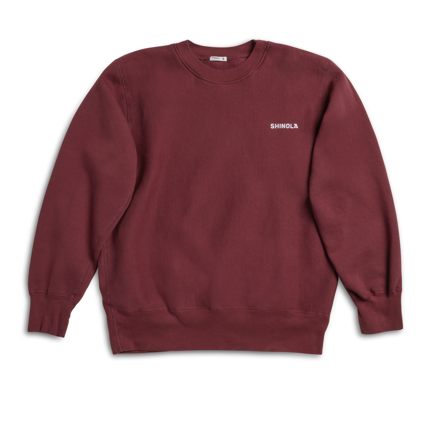 The Shinola Fleece Logo Sweatshirt - Merlot features a unisex classic fit, long sleeves, and "Shinola" in small white letters on the left chest. Made from soft American cotton fleece, it appears laid flat on a white background.