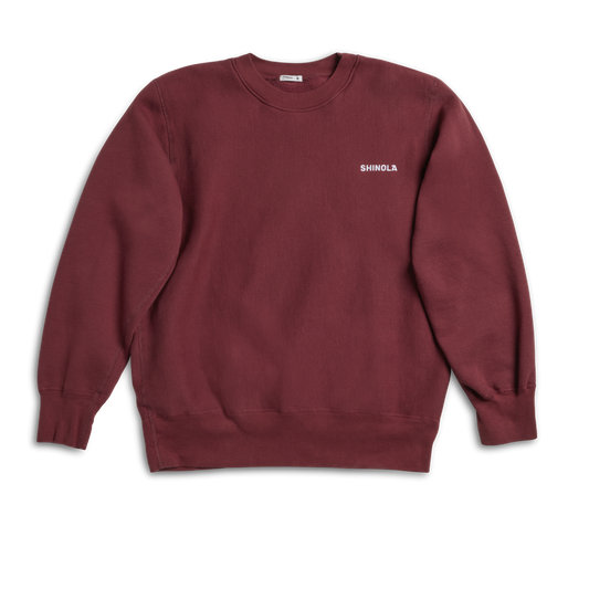 The Shinola Fleece Logo Sweatshirt - Merlot features a unisex classic fit, long sleeves, and "Shinola" in small white letters on the left chest. Made from soft American cotton fleece, it appears laid flat on a white background.