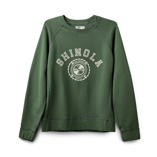 The Shinola Logo Sweatshirt - Leaf is a green unisex French Terry sweatshirt featuring a white SHINOLA logo and circular design on the chest, with long sleeves and ribbed cuffs and hem for comfort.