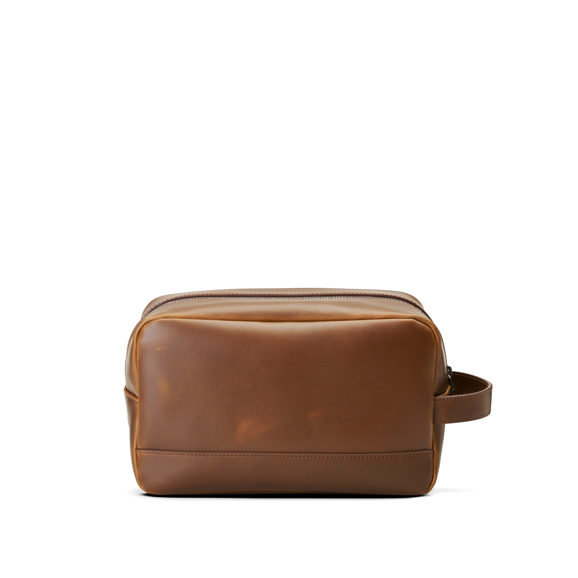 The Shinola Zip Travel Kit - Medium Brown is a stylish, water-resistant leather toiletry bag with a zippered top and side handle, shown against a plain white background.