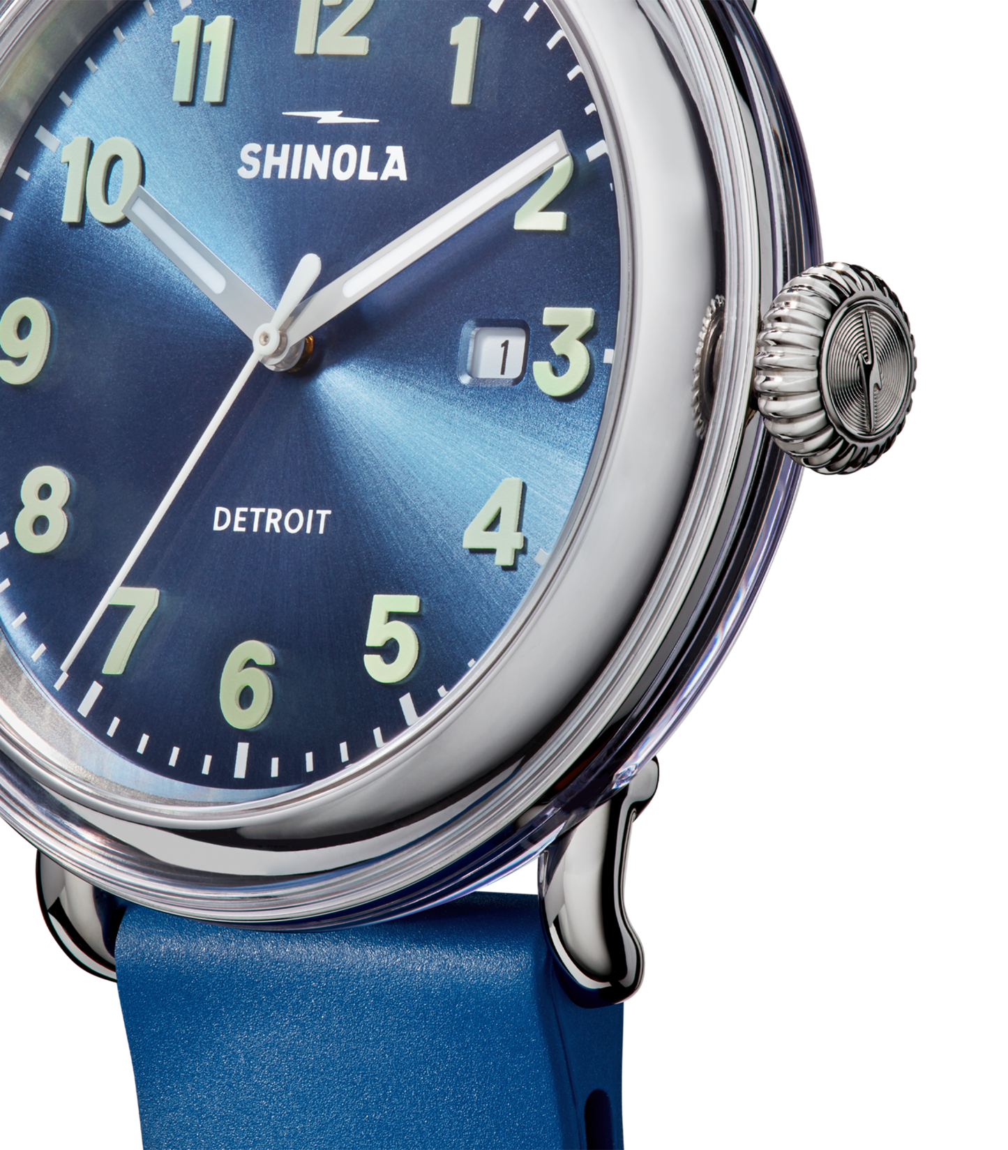 Close-up of the Shinola Detrola Watch - Denim Blue, featuring a blue face with white numerals, date window, silver casing, blue strap, and "DETROIT" printed on the dial.