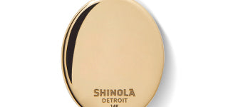 A gold, oval-shaped pendant engraved with Shinola is shown against a white background, resembling the Diamond Pave Lapis Pendant Necklace in yellow gold.