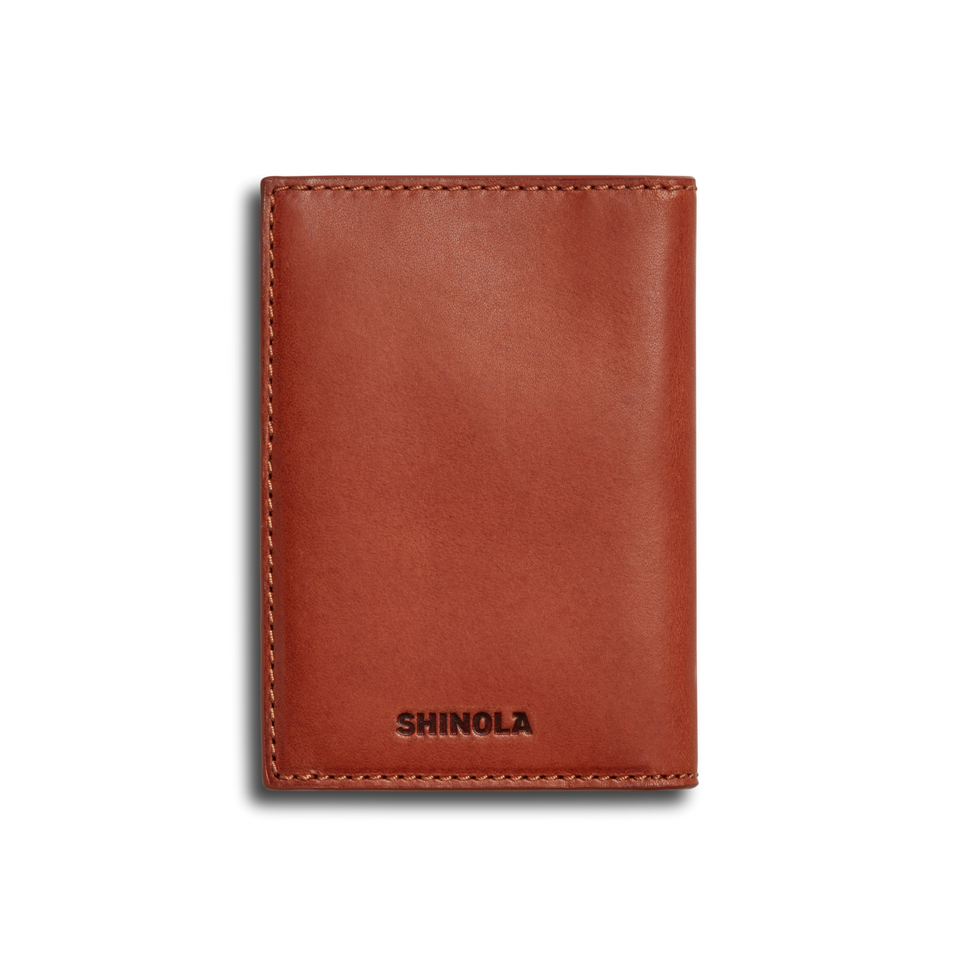 The Shinola Folded Card Holder - Rust is a brown leather wallet made from premium Italian Vachetta leather, featuring visible edge stitching and "SHINOLA" embossed at the bottom, shown closed against a white background.