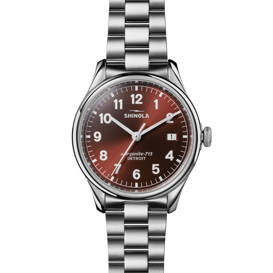 The Shinola Vinton Watch - Whiskey features a round case, stainless steel bracelet, whiskey-colored dial with white Arabic numerals, three hands, and the Shinola logo above the center.