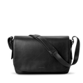 The Shinola Runwell Messenger Bag in black features a flap closure, padded laptop sleeve, and adjustable crossbody strap, displayed against a plain white background.