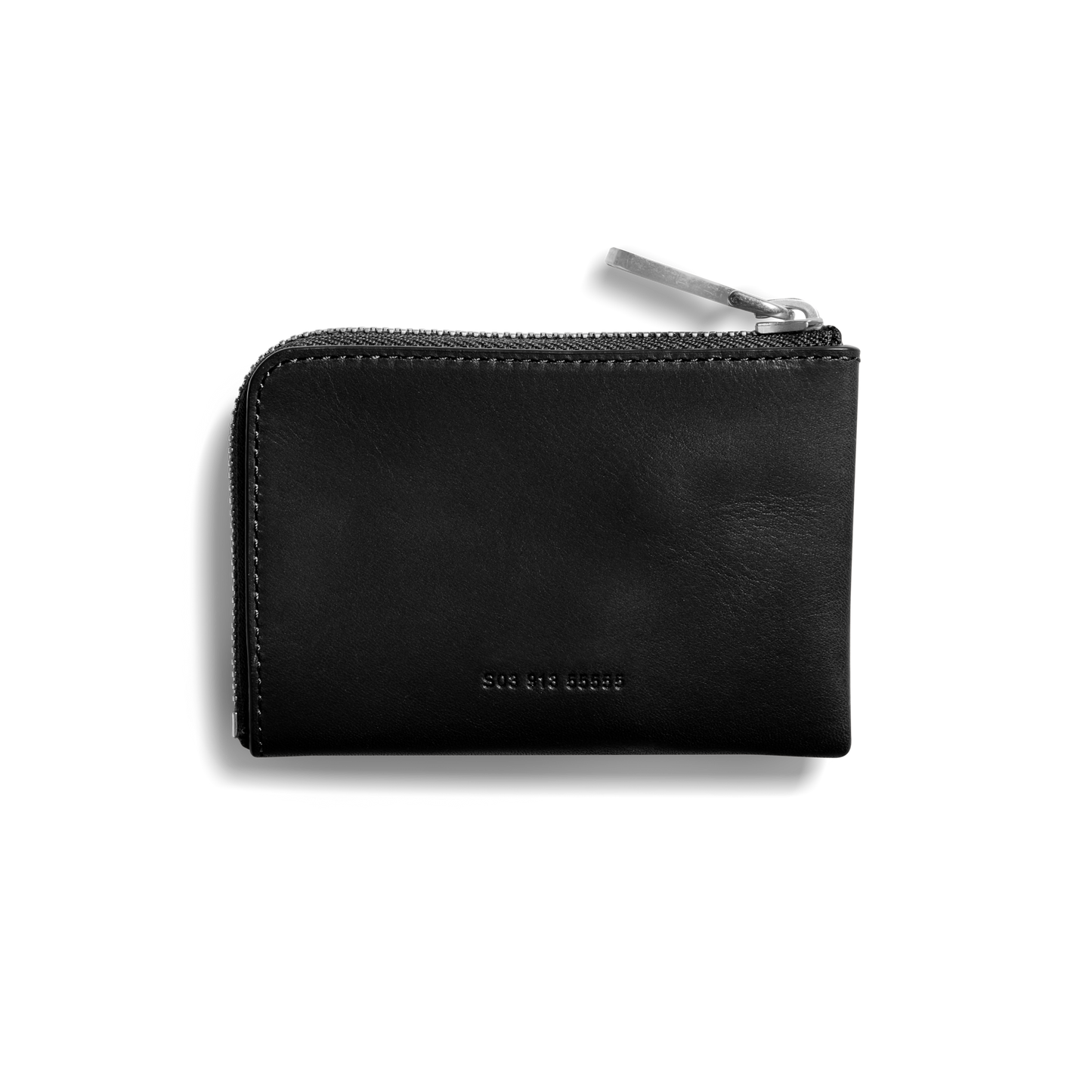 The Shinola Zip Key Wallet - Black is a minimalist vegetable-tanned leather wallet with a silver zip-around closure and small embossed front text, photographed against a plain white background.