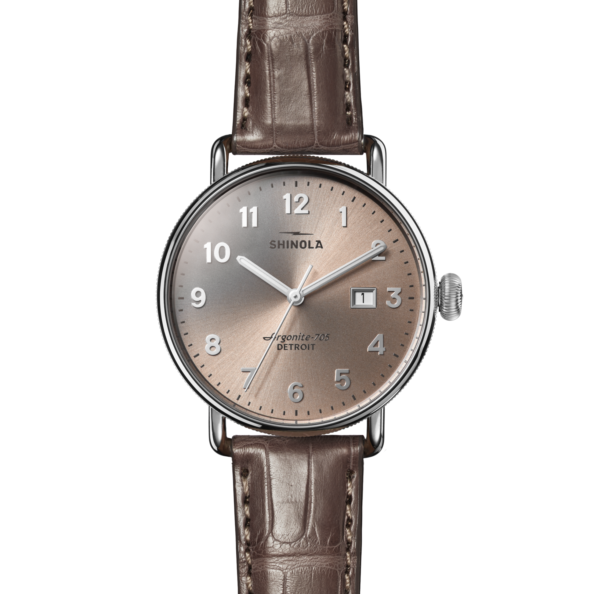 The Shinola Canfield Watch features a 38mm silver round case, gray-brown American alligator leather strap, taupe dial with silver hour markers, and date window at 3 o’clock. The dial reads “SHINOLA” and “Argonite-705 DETROIT.”.