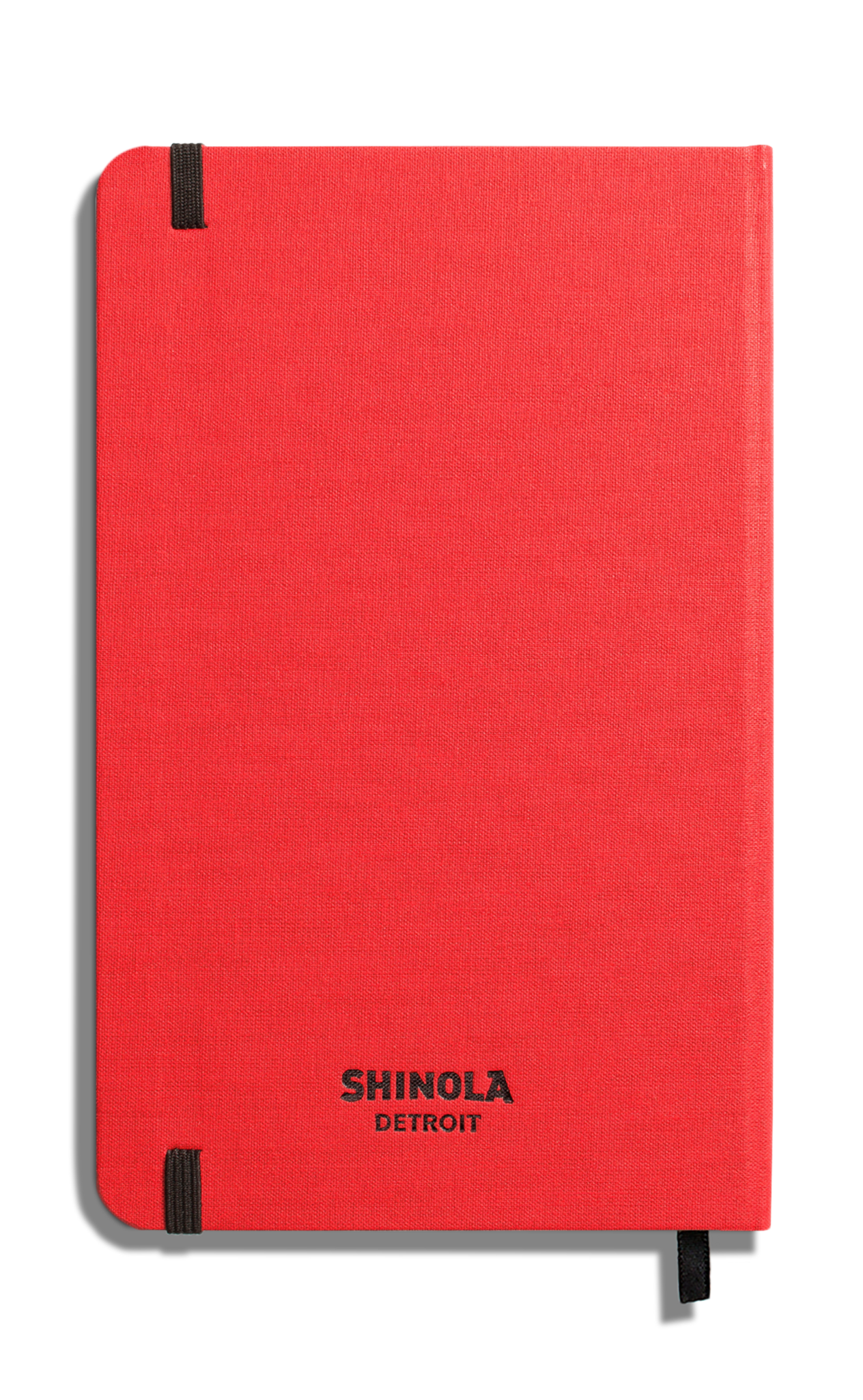 The Medium Hard Ruled Journal - Tomato by Shinola is a red hardcover notebook with smyth-sewn binding, rounded corners, black elastic bands, and "Shinola Detroit" printed in black on the front cover against a white background.