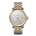 The Shinola Runwell Watch - Mother Of Pearl features a two-tone stainless steel bracelet, white mother of pearl dial with gold numerals and hands, small seconds subdial, and gold-toned crown and bezel.
