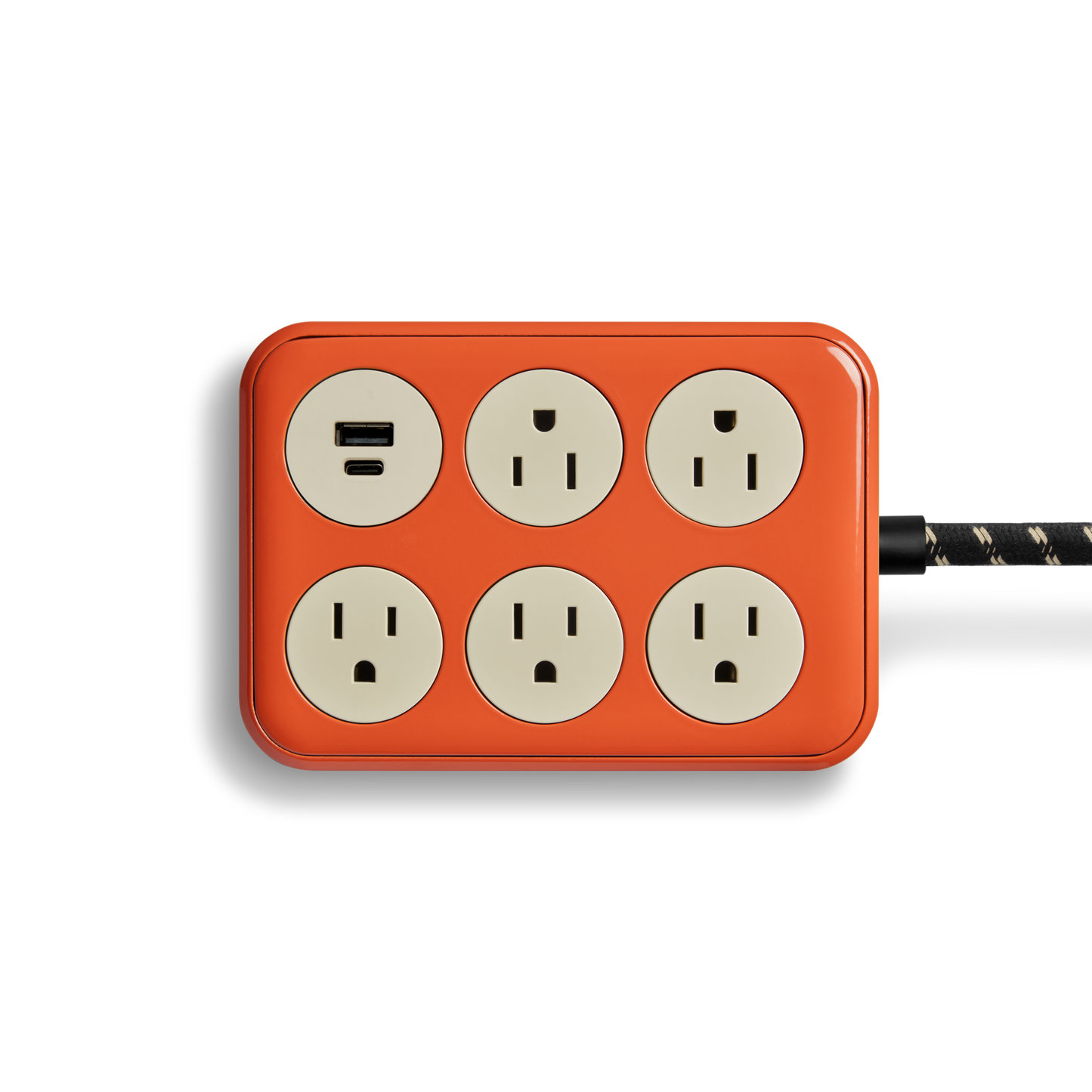 The Shinola 5 Port Power Supply - Tangerine is a rectangular orange strip with six cream-colored sockets, one USB A + C port, and a black-and-white braided cord extending from the right side.