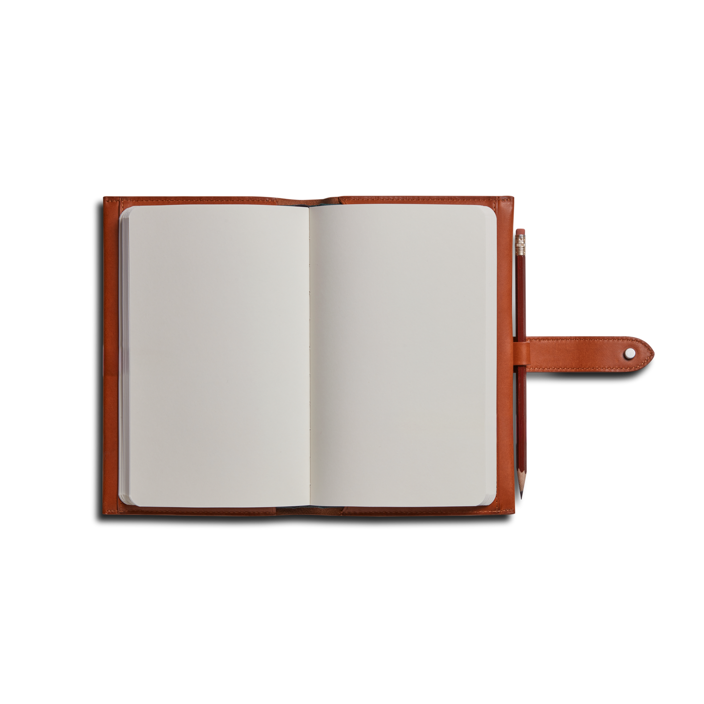 A Shinola Medium Snap Journal Cover in rust Italian leather with blank white pages, snap closure, and a pencil in the right-side loop, photographed on a white background.