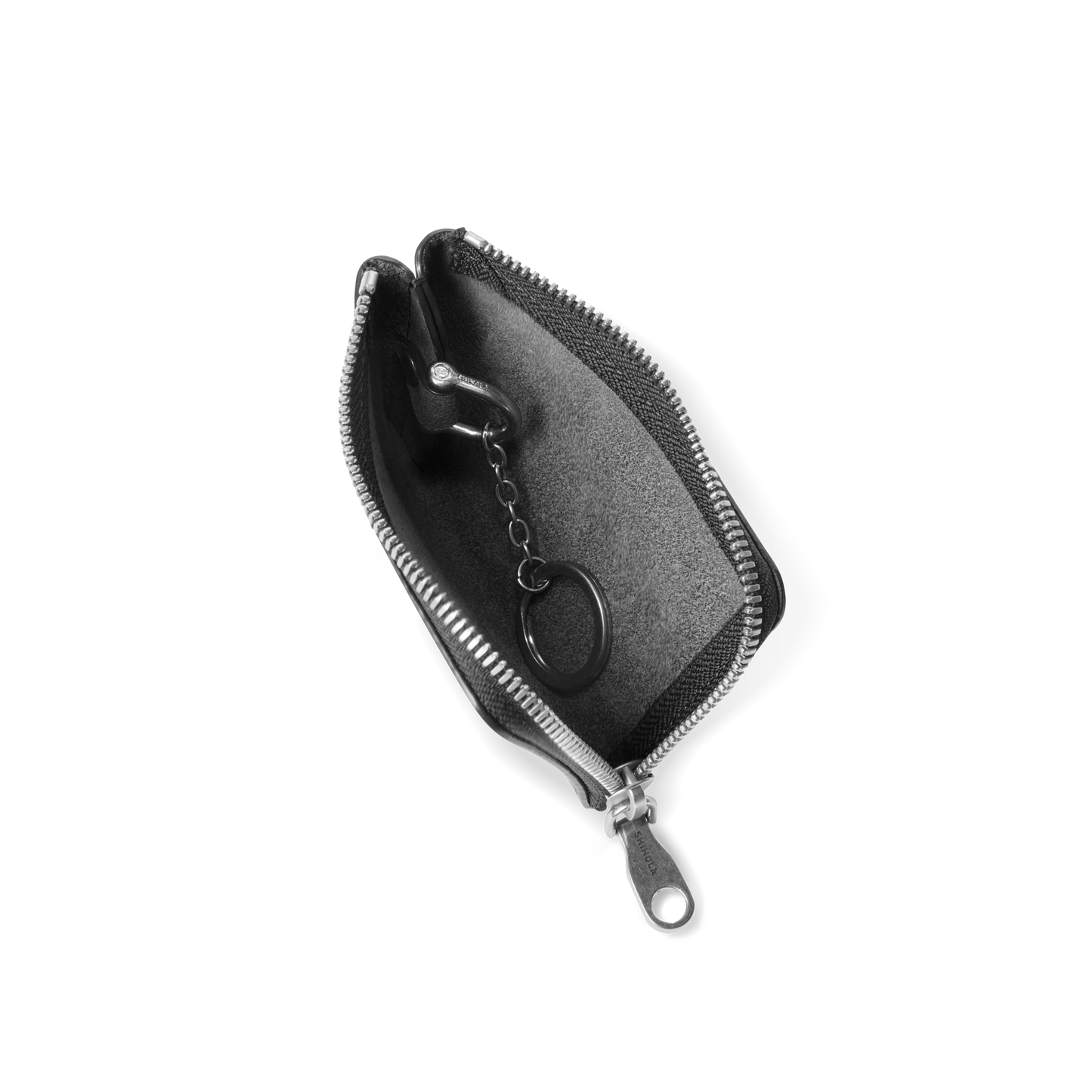 The Shinola Zip Key Wallet - Black, crafted from vegetable tanned leather, is shown open on a white background, displaying its zip around closure and key ring with a short chain inside.